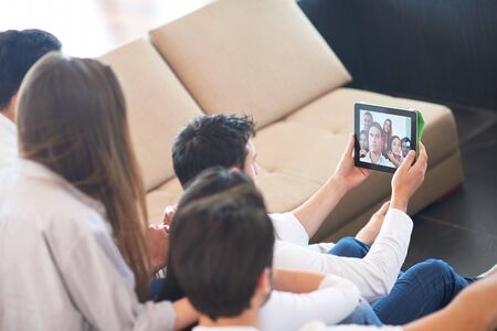 group of friends taking selfie photo with tablet at modern home indoors
