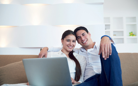 happy young relaxed  couple working on laptop computer at modern home interiorの写真素材