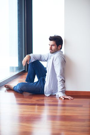 relaxed young man drink first morning coffee at modern home indoors at rainy window drops windowの写真素材