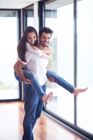 happy young romantic couple have fun relax smile at modern home livingroom interiorの写真素材