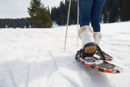 happy young  couple having fun and walking in snow shoes outdoor in nature at beautiful winter day. Health sport and relaxationの写真素材