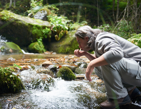 hiking in beautiful nature, man drink fresh water from spring
