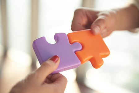 business people group assembling jigsaw puzzle and represent team support and help concept, top view...