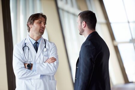 doctor handshake with a patient at doctors bright modern office in hospitalの写真素材