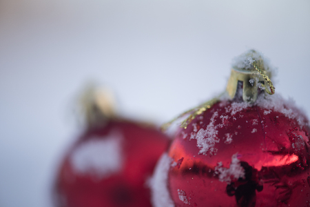 christmas red balls decoration in fresh snow background on beautiful sunny winter dayの写真素材