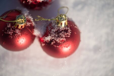 christmas red balls decoration in fresh snow background on beautiful sunny winter dayの写真素材