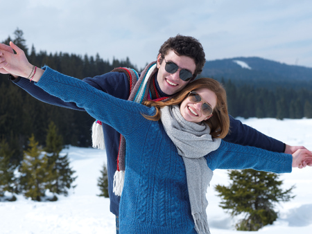romantic winter  scene, happy young couple having fun on fresh show on winter vacatio, mountain nature landscapeの写真素材