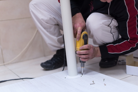 repairman working with drilling machine and assambling  furnitureの写真素材