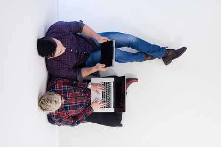 startup business and new mobile technology concept with  young couple in modern bright office interior working on laptop and tablet computer on new creative project and brainstorming, aerial top viewの写真素材