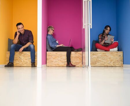 group of young business people having fun, relaxing and working in creative room space at modern...
