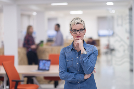 portrait of young business woman at modern startup office interior, team in meeting in backgroundの写真素材