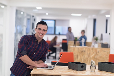portrait of young businessman in casual clothes at modern  startup business office space,  working on laptop  computerの写真素材
