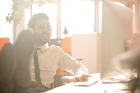 happy young arabian  business man with beard  listening music on headphones at modern startup office