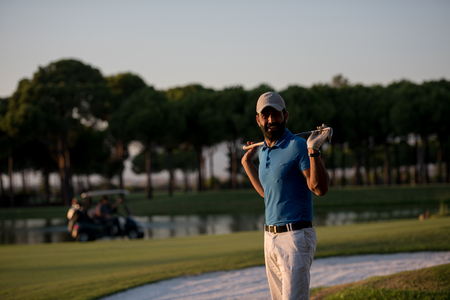 handsome middle eastern golfer portrait at golf course at beautiful sunsetの写真素材