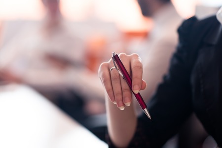 close-up of woman hands holding pen on business meetingの写真素材