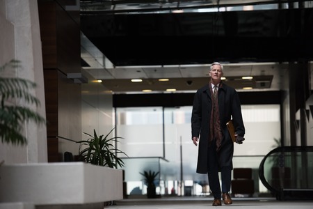 handsome and sucessful senior business man walking in modern office interiorの写真素材