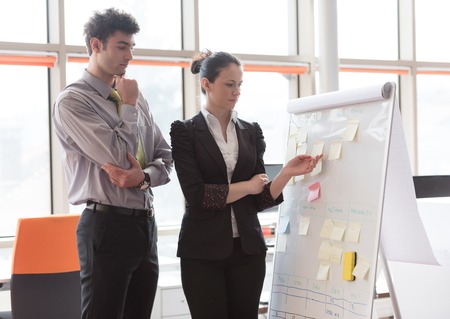 successful young startup business people group brainstorming  planning projects and taking notes to...