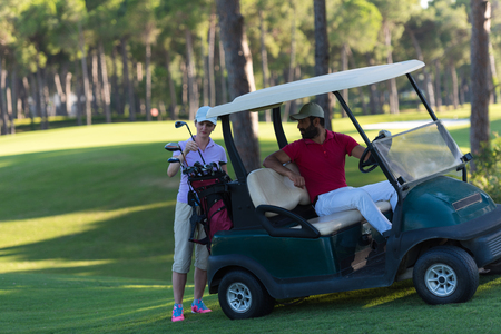couple in buggy cart on golf courseの写真素材