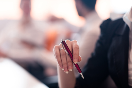 close-up of woman hands holding pen on business meetingの写真素材