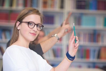 group of  smart students raise hands up in school  classroom on class