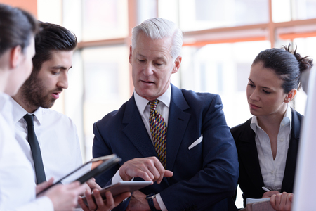 young startup businessman making presentation of project to senior investior, group of business people taking notes and make plans on white  flip board and tablet computerの写真素材