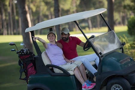 couple in buggy cart on golf courseの写真素材