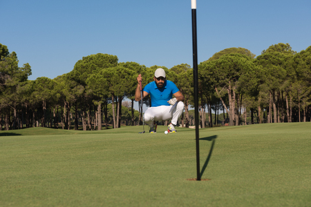 golf player aiming shot with club on course at beautiful sunny dayの写真素材