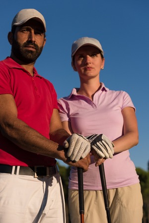 portrait of happy young  couple on golf courseの写真素材