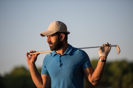 handsome middle eastern golfer portrait at golf course at beautiful sunsetの写真素材