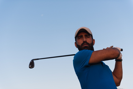 handsome middle eastern golfer portrait at golf course at beautiful sunsetの写真素材