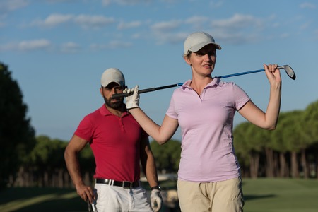 portrait of happy young  couple on golf courseの写真素材