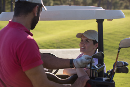 couple in buggy cart on golf courseの写真素材