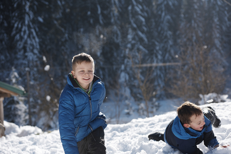 happy kids playing in fresh snow at beautiful  sunny winter dayの写真素材
