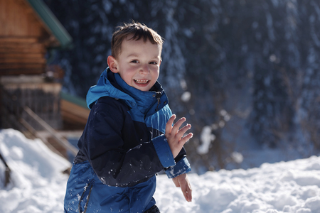 happy kids playing in fresh snow at beautiful  sunny winter dayの写真素材