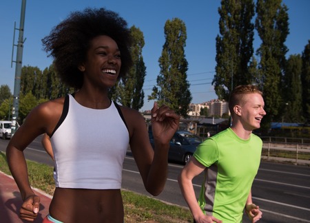multiethnic group of young people on the jogging beautiful morning as the sun rises in the streets...