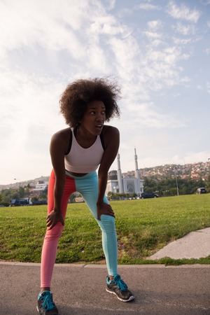 portrait of a young African American girl to run beautiful summer morning on city streetsの写真素材