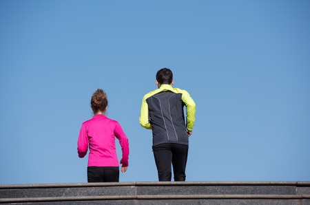 healthy young  couple jogging on steps  at early morning