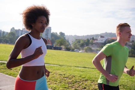 multiethnic group of young people on the jogging beautiful morning as the sun rises in the streets...
