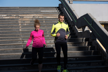 healthy young  couple jogging on steps  at early morning