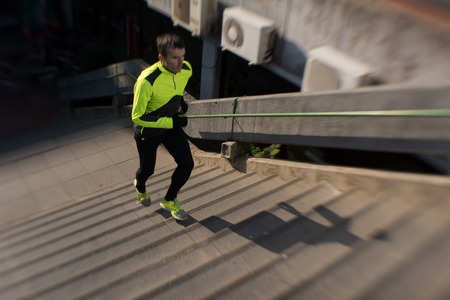 man jogging  at cold autumn  mornigng on stepsの写真素材
