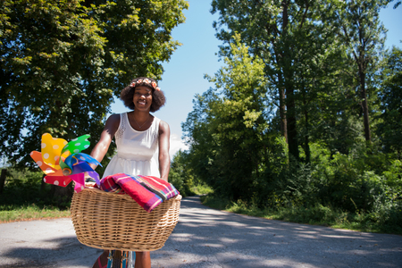 beautiful young African American women enjoy while riding a bicycle in the woods on a sunny summer dayの写真素材