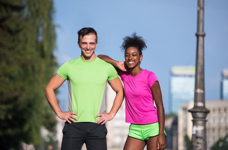 portrait of young multietnic jogging couple ready to run on fresh morning in the cityの写真素材