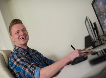 Young graphic designer working on a digital tablet and a computerの写真素材