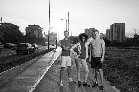 Portrait of multi-ethnic group of young people on the jogging beautiful summer evening as the sun sets over the cityの写真素材