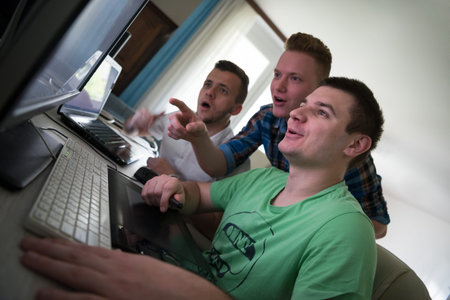 a group of young graphic designers working on a digital tablet and a computer
