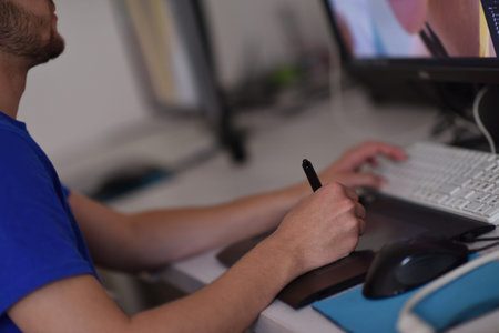 Young graphic designer working on a digital tablet and a computer