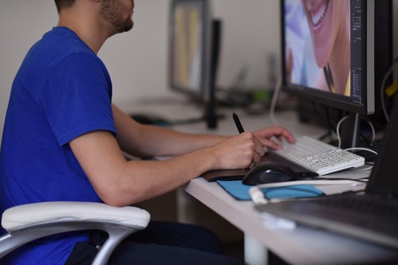 Young graphic designer working on a digital tablet and a computerの写真素材