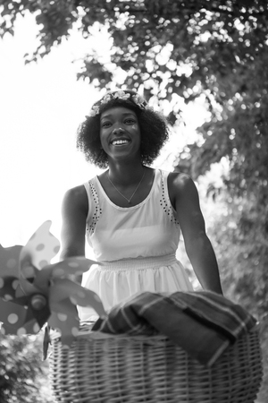beautiful young African American women enjoy while riding a bicycle in the woods on a sunny summer dayの写真素材