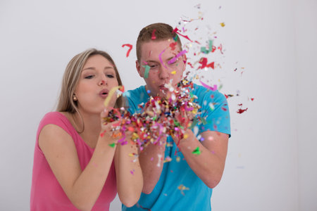happy young romantic  couple in love  celebrating and blowing confetti decorations at new year and...