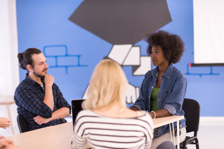 Multiethnic startup business team on meeting in modern bright office interior brainstorming, working on laptop and tablet computerの写真素材